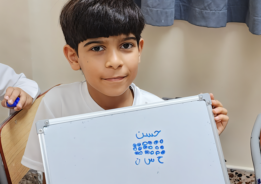 محمود.. طالب من ذوي الإعاقة البصرية يقدم شرحًا لزملائه عن جهاز (برايل)