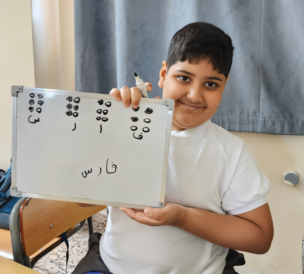 محمود.. طالب من ذوي الإعاقة البصرية يقدم شرحًا لزملائه عن جهاز (برايل)