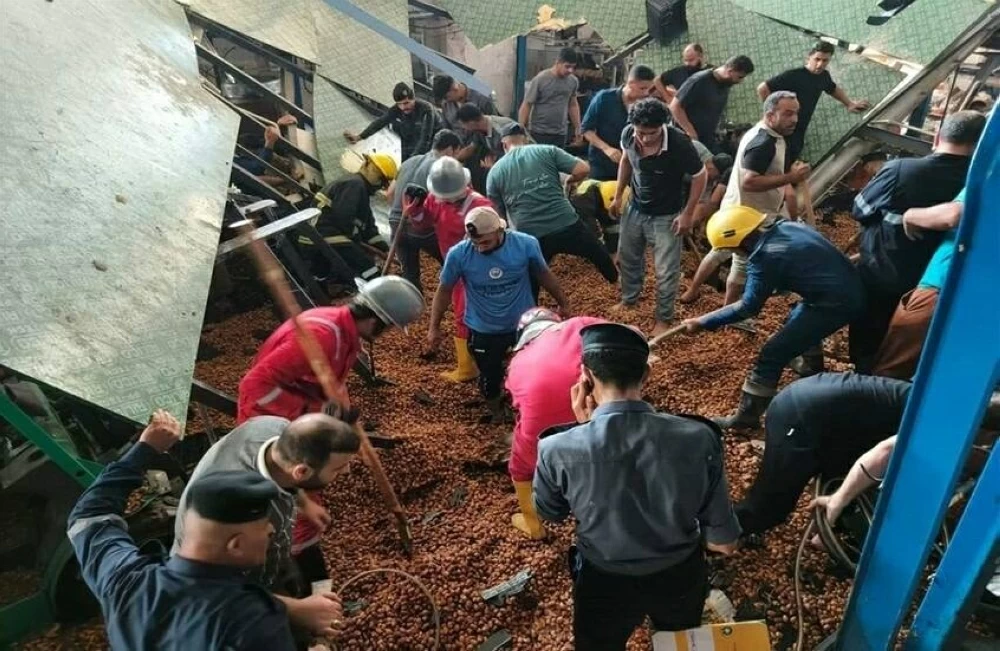 إنقاذ 4 عمال طمرتهم أطنان من التمور في العراق (صور)