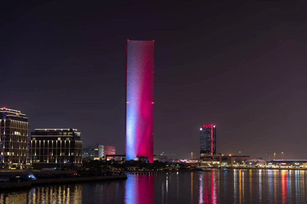 مباني المنامة تتشح باللونين العنابي والأبيض احتفاءً بالعيد الوطني القطري