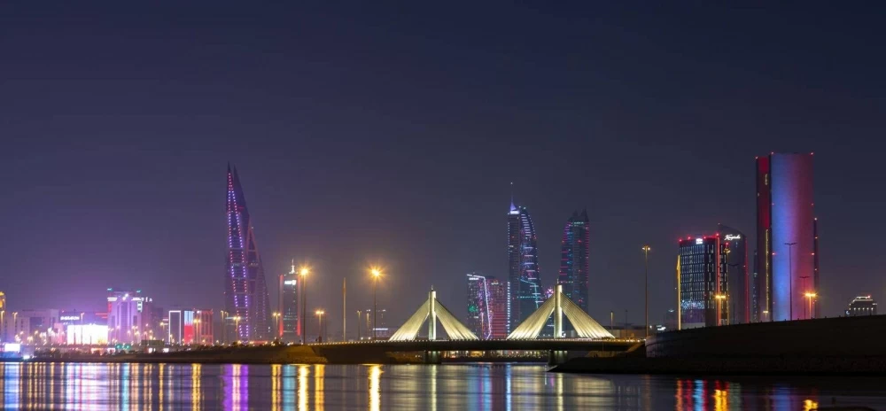 مباني المنامة تتشح باللونين العنابي والأبيض احتفاءً بالعيد الوطني القطري